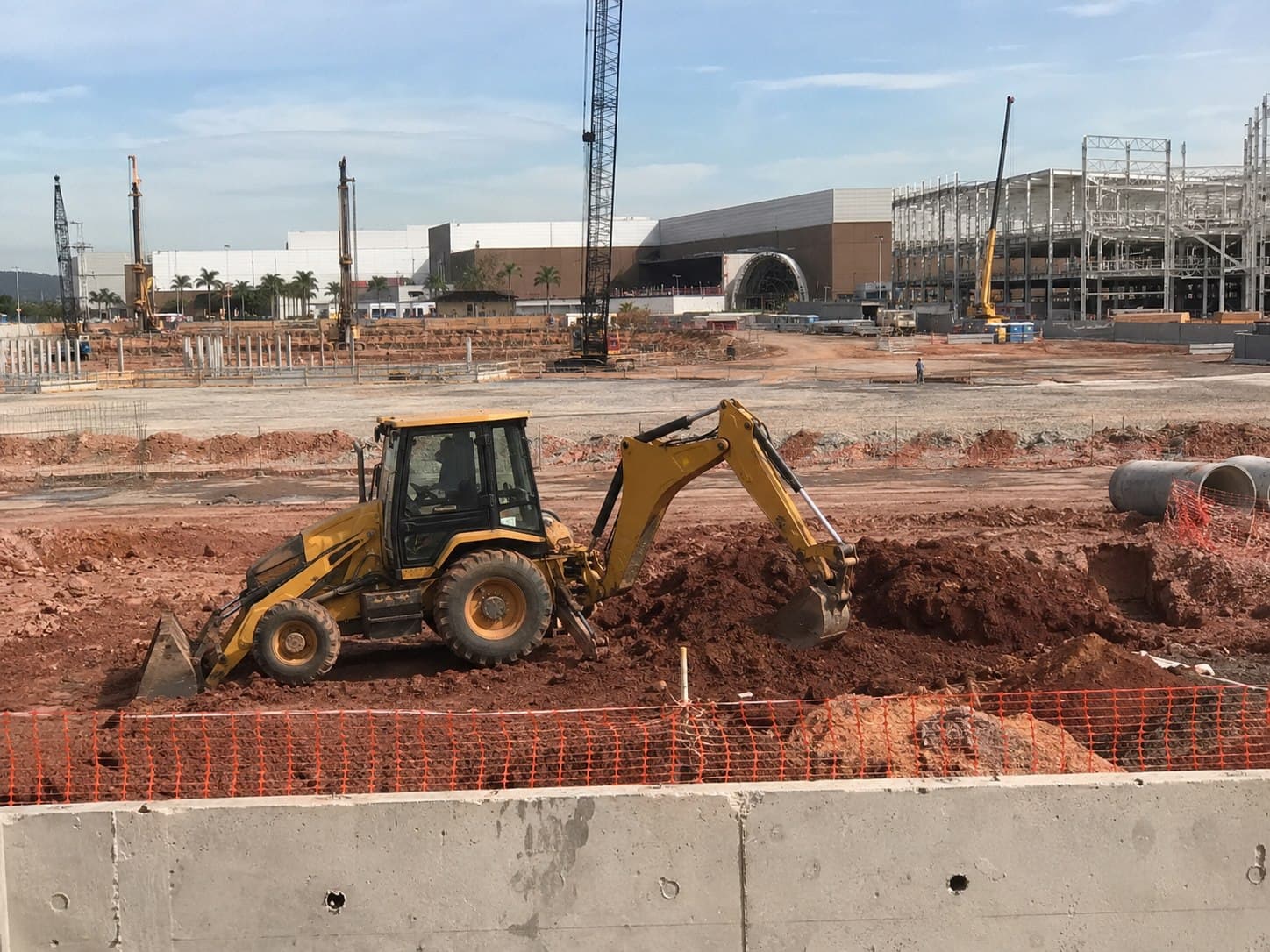 Retroescavadeira da Cairuru Construtora em operação em obra comercial de shopping no Rio de Janeiro